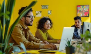 Zwei Menschen arbeiten zusammen vor dem Rechner an gemeinsamen Texten.